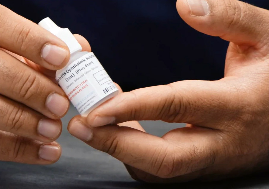 Topical Losartan ophthalmic solution bottle being held